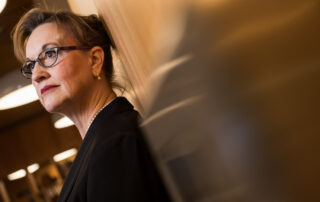 Picture of author deep in thought leaning against a wall.